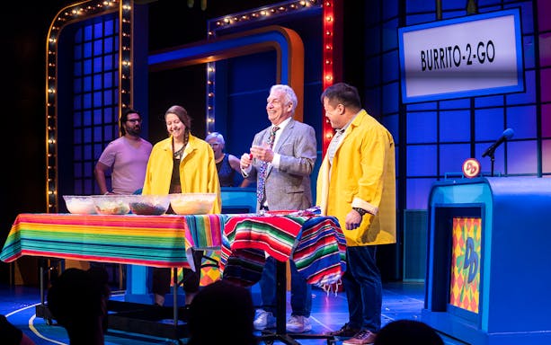 Participants on stage during "The Life and Slimes of Marc Summers" show, with colorful table setup.