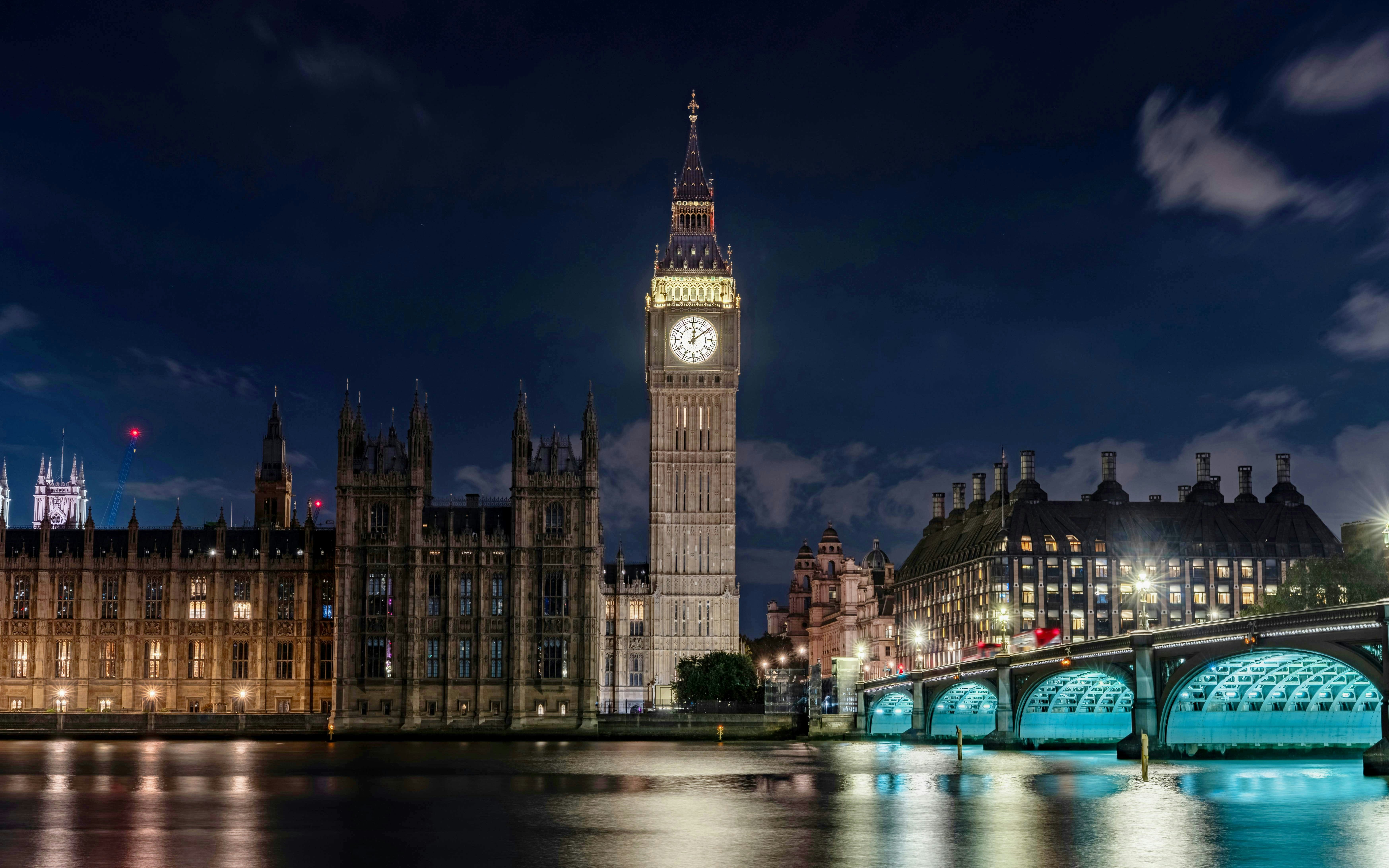 Big Ben and Westminster Bridge illuminated at night in London.