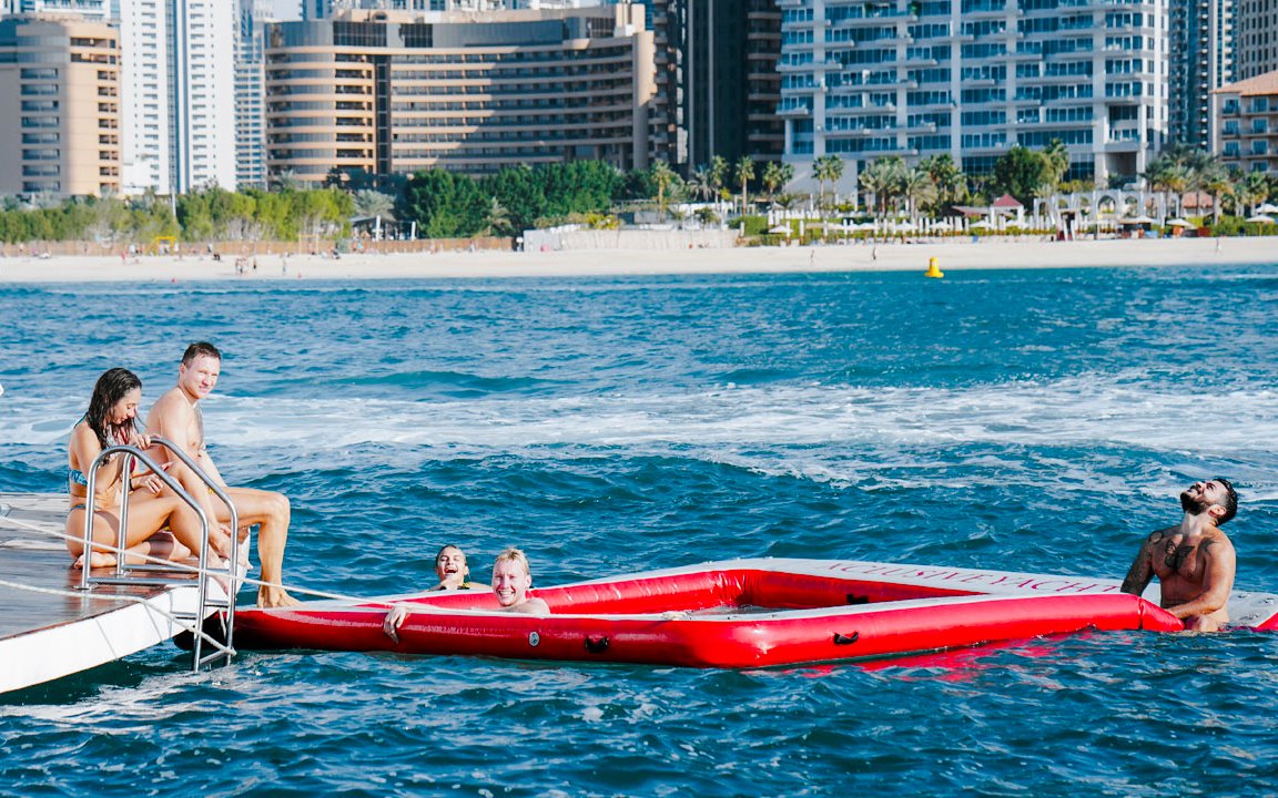 Visitors enjoying floaties on a luxury yacht cruise in Dubai.