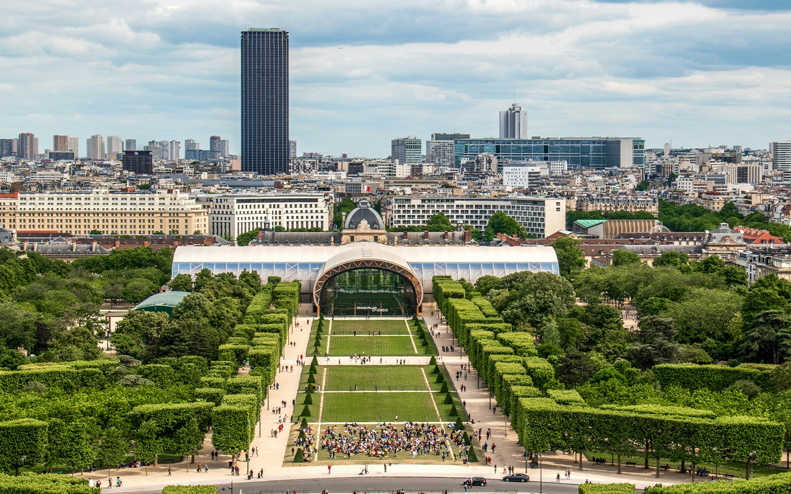 Grand Palais in Paris with surrounding gardens and city skyline.