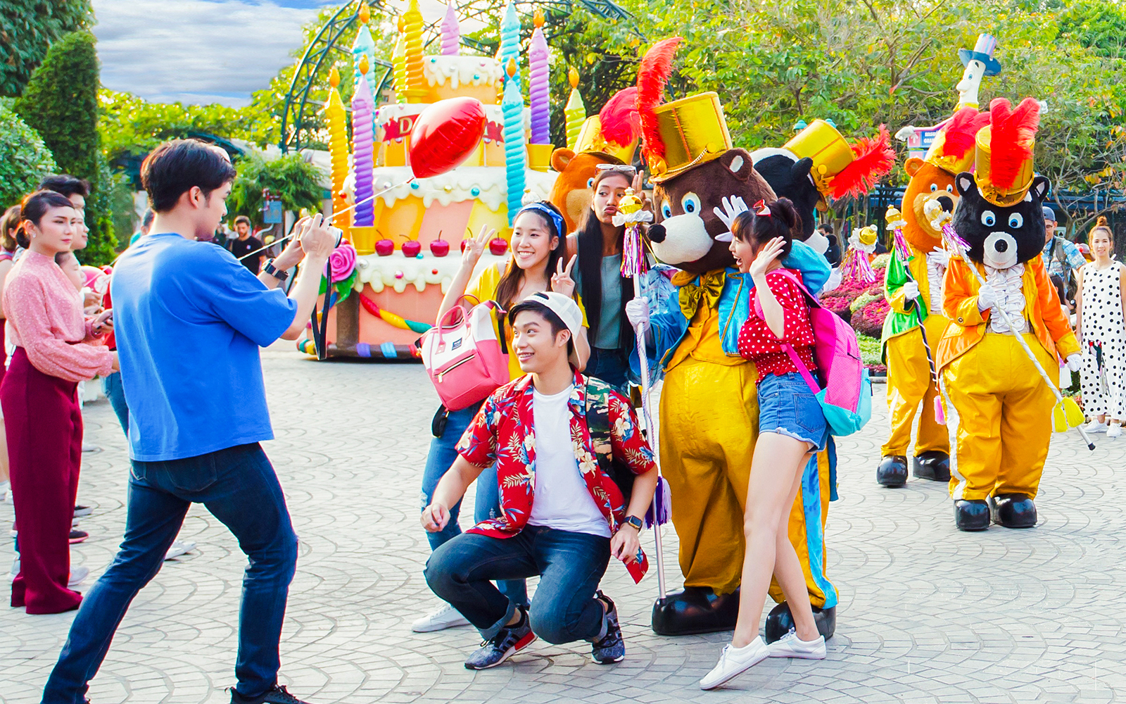 Visitors posing with costumed characters at Dreamworld Bangkok street show.