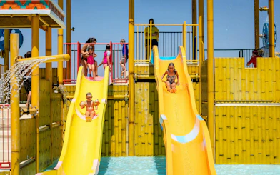 Children sliding down water slides at Aqualand Algarve's Children's Paradise.