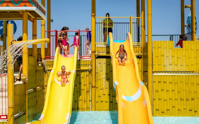 Children sliding down water slides at Aqualand Algarve's Children's Paradise.