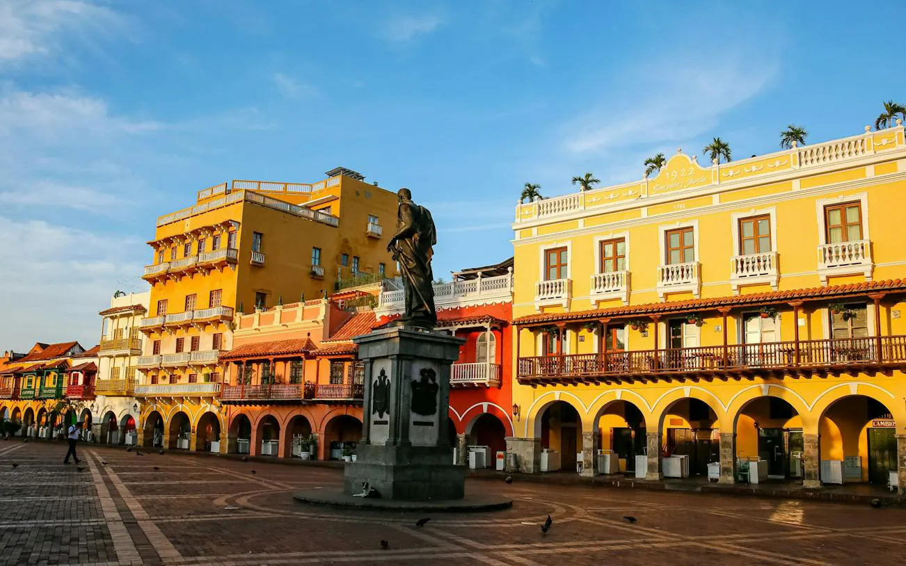 Statue in Plaza de los Coches with colorful colonial buildings, Cartagena.