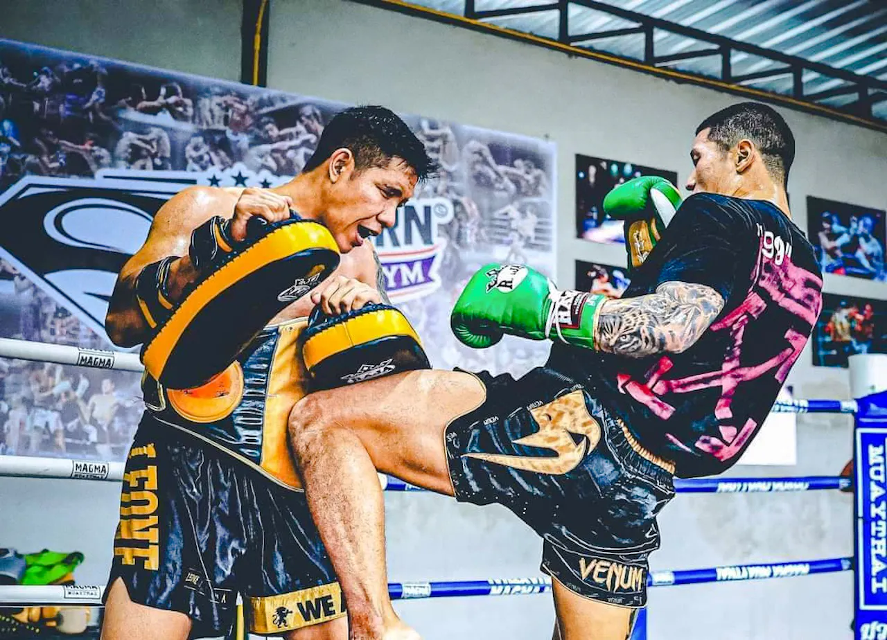 Muay Thai training session with beginners practicing kicks in Pattaya gym.