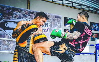 Muay Thai training session with beginners practicing kicks in Pattaya gym.