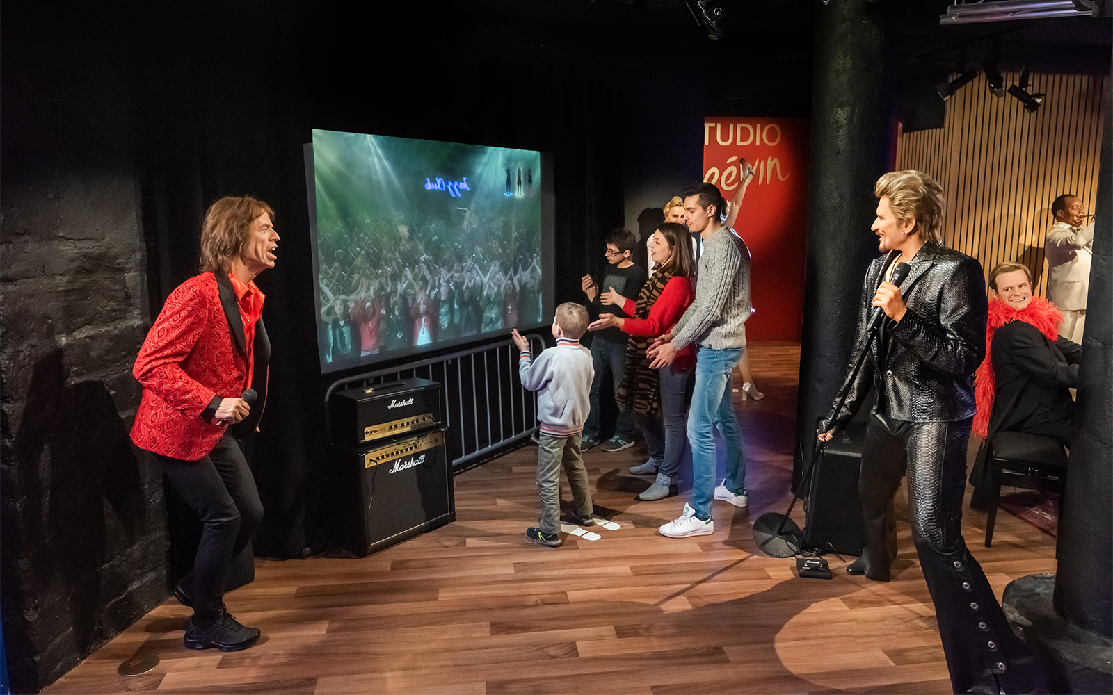 Family interacting with wax figures at Grévin Wax Museum, Paris.
