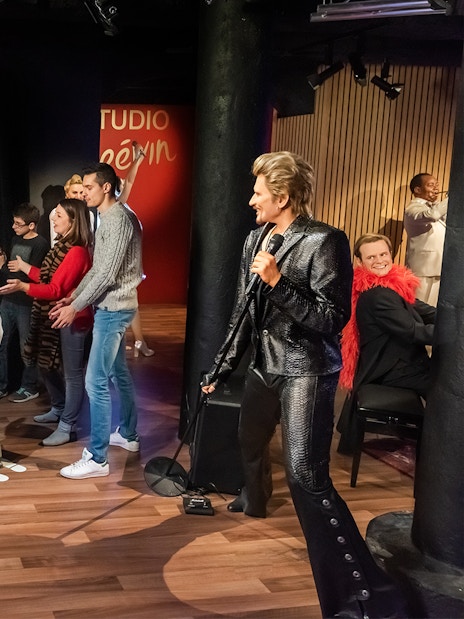Family interacting with wax figures at Grévin Wax Museum, Paris.