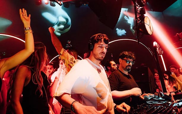 DJ performing at Club Chinois, Ibiza with crowd enjoying the music.