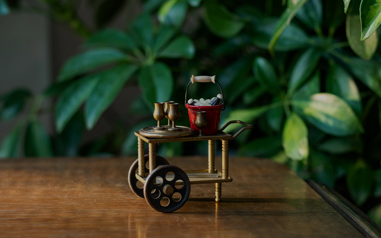 Miniature tea cart with cups and a red bucket, part of Queen Mary Doll House Garage.