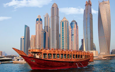 Dhow boat cruising in Dubai Marina with skyscrapers in the background.