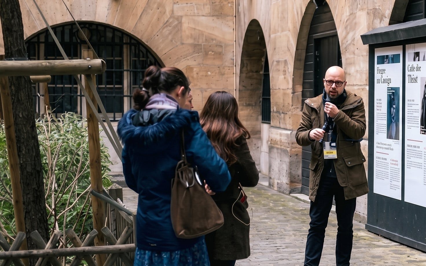 Tour guide explaining history to visitors at Sainte Chapelle and Conciergerie in Paris.