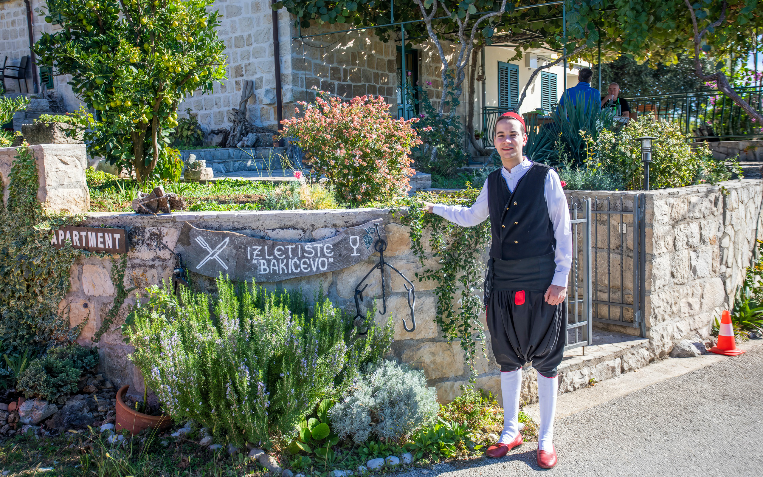 Country House Bakicevo entrance with traditional attire in Cilipi, Croatia.