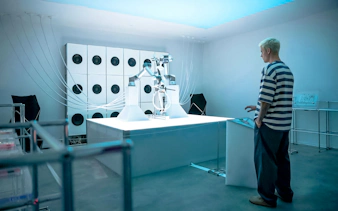 Robotic arm playing cello at Mercer Labs Museum of Art exhibit.