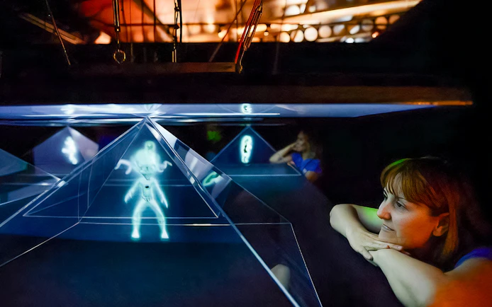 Visitors observing holographic display at Valencia Science Museum, part of Oceanogràfic and Hemisfèric combo tickets.