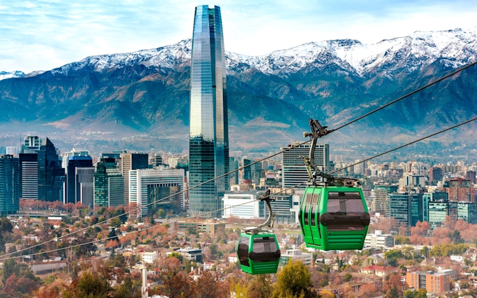Santiago cable car with city skyline and Andes mountains in the background.