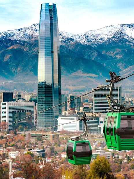 Santiago cable car with city skyline and Andes mountains in the background.