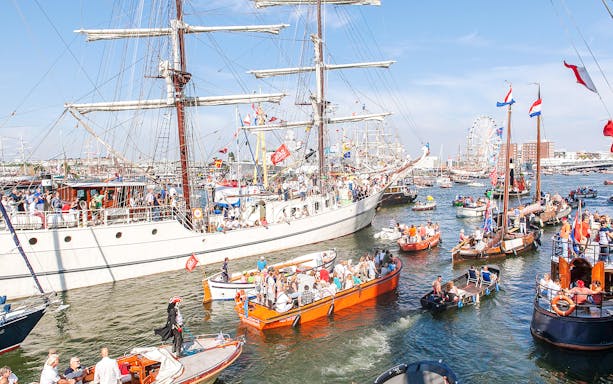 Tall ships and boats crowd the harbor during SAIL Amsterdam festival.