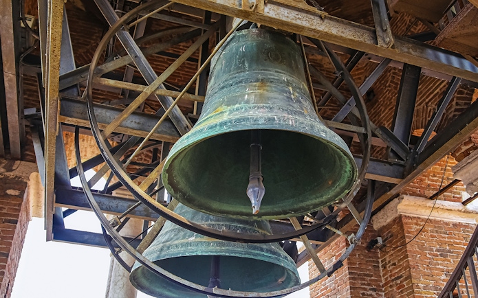 Bells inside Mark’s Bell Tower, Venice, showcasing intricate metalwork.