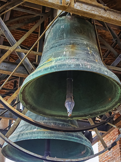 Bells inside Mark’s Bell Tower, Venice, showcasing intricate metalwork.