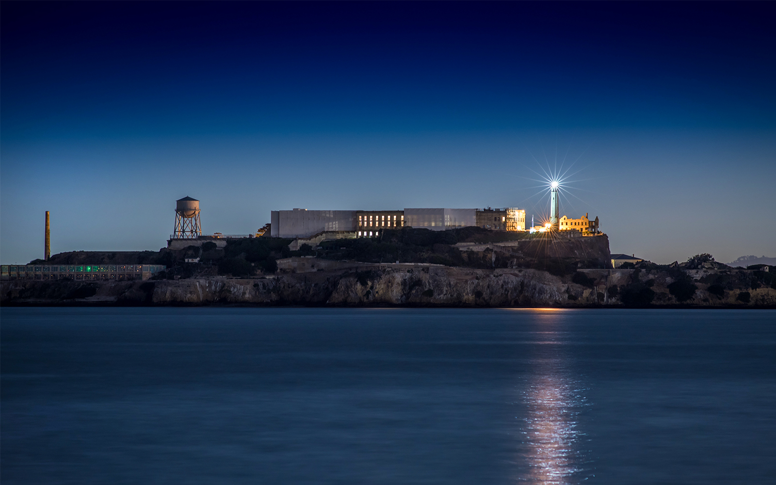 Alcatraz Island with lighthouse illuminated at night, San Francisco Bay.