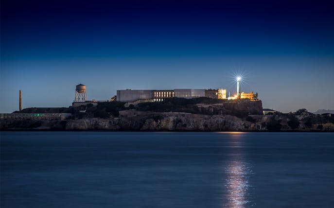 Alcatraz Island with lighthouse illuminated at night, San Francisco Bay.