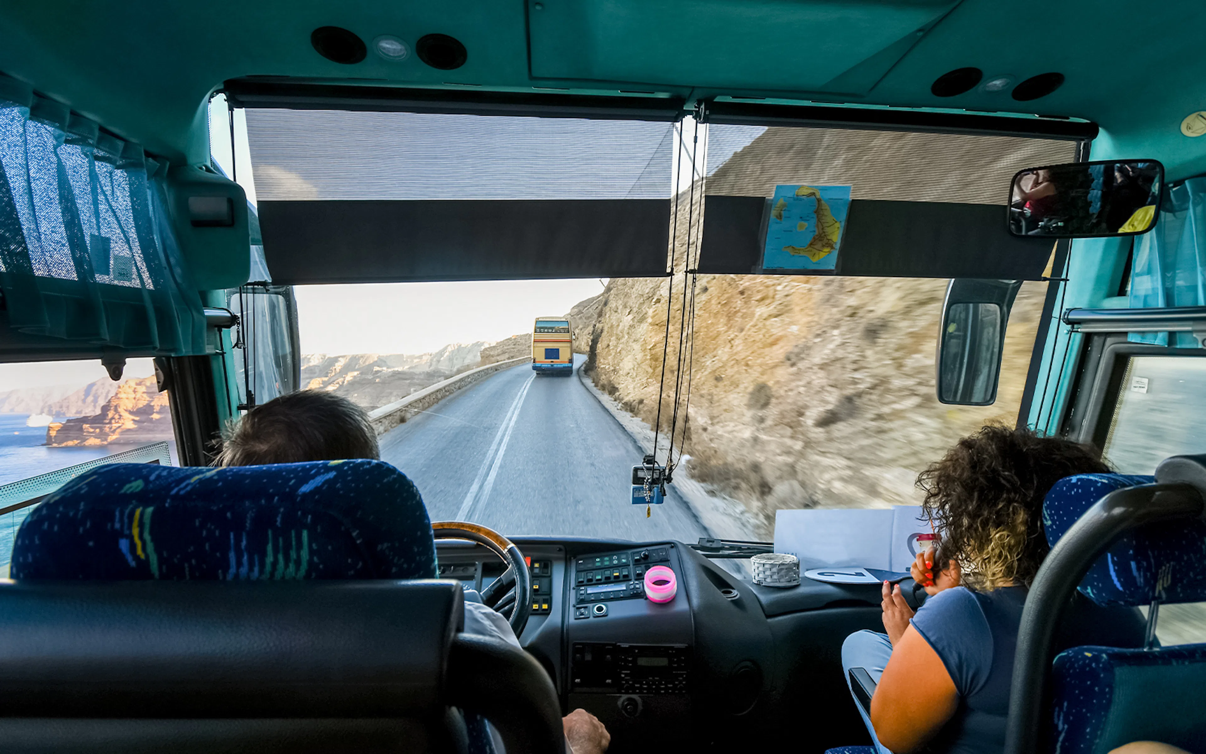 Tour bus on winding road from Thera to cruise port, Santorini, Greece.