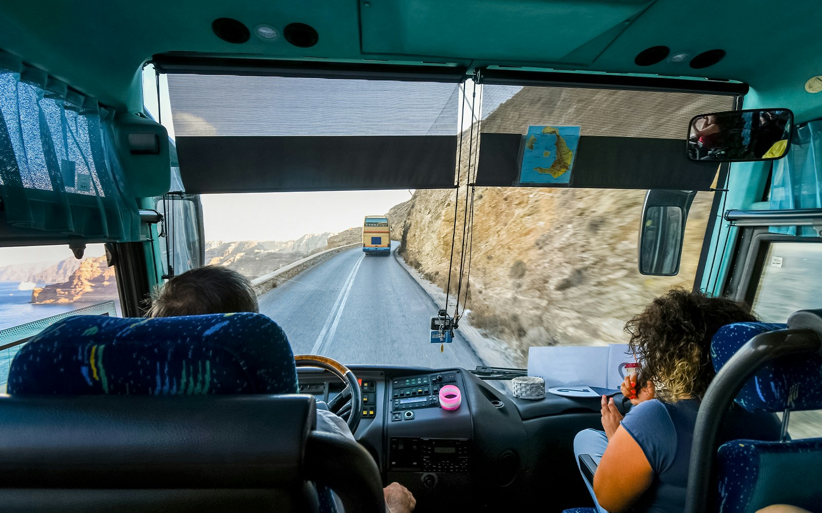 Tour bus on winding road from Thera to cruise port, Santorini, Greece.