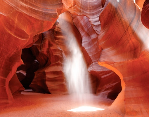 Sunbeam illuminating Upper Antelope Canyon's red sandstone walls, Page, Arizona.