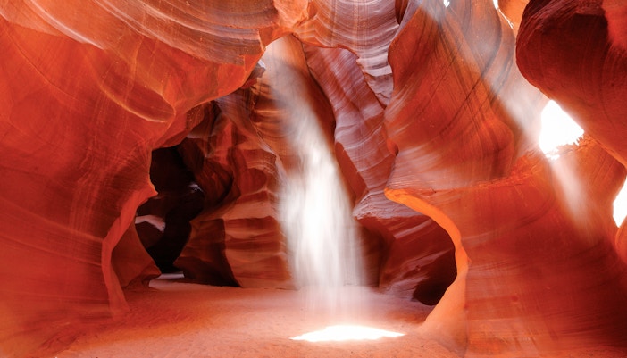 Sunbeam illuminating Upper Antelope Canyon's red sandstone walls, Page, Arizona.