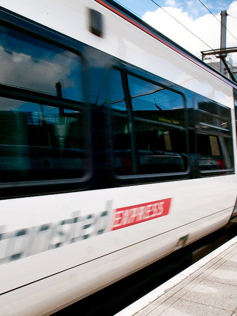 Stansted Express train arriving at a modern train station platform.