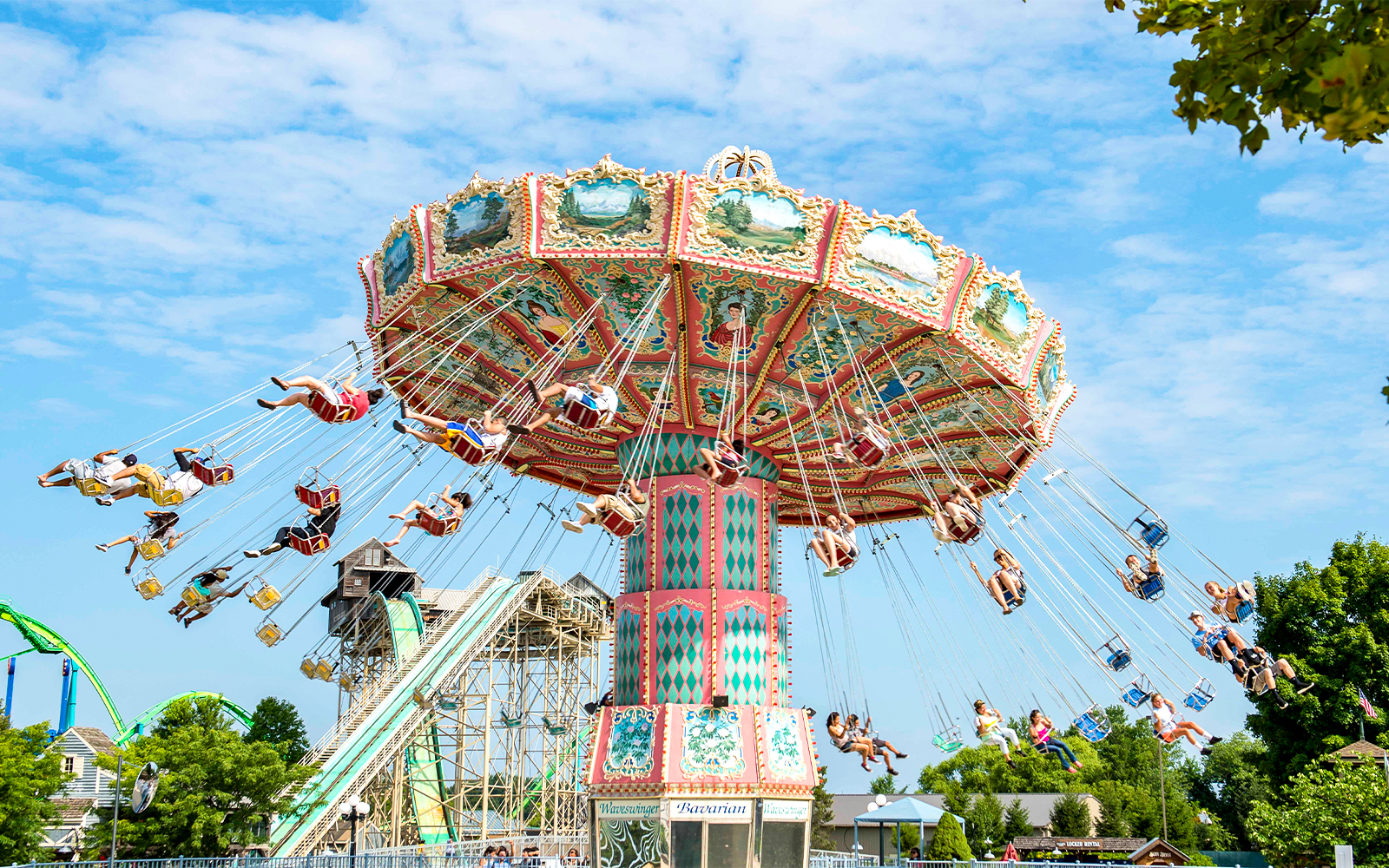 Wave Swinger ride at Dorney Park with people enjoying the swings against a clear sky.