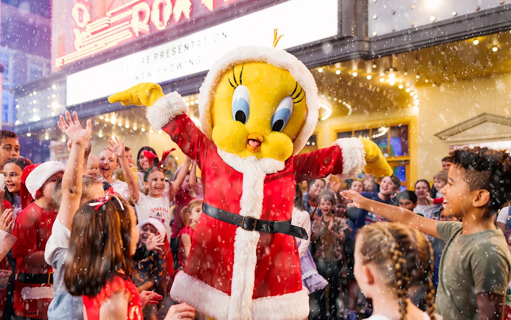 Character in Santa outfit with children celebrating at Warner Bros. Movie World, Gold Coast.