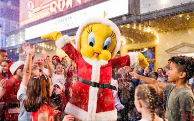 Character in Santa outfit with children celebrating at Warner Bros. Movie World, Gold Coast.
