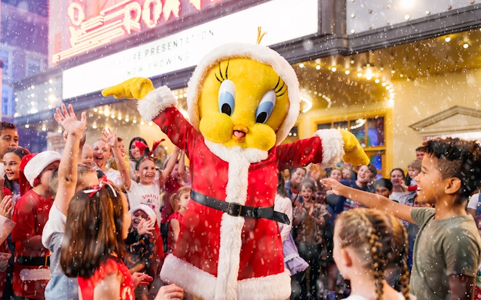 Character in Santa outfit with children celebrating at Warner Bros. Movie World, Gold Coast.