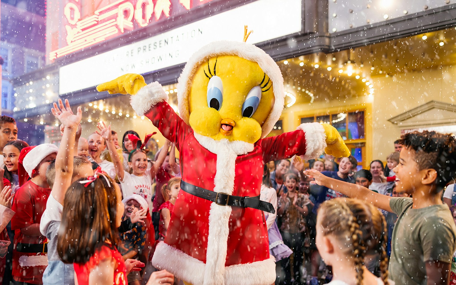Character in Santa outfit with children celebrating at Warner Bros. Movie World, Gold Coast.