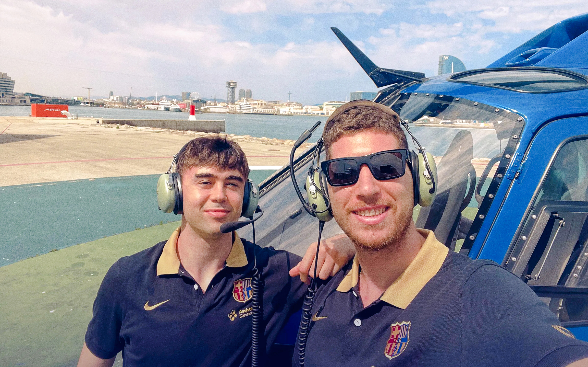Tourists with headsets beside helicopter on Barcelona sky tour.