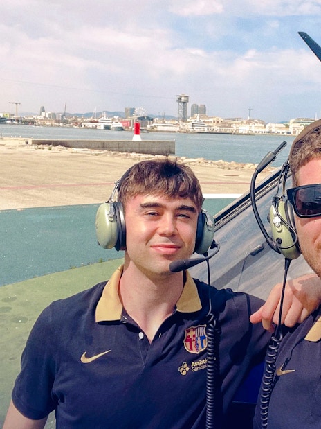 Tourists with headsets beside helicopter on Barcelona sky tour.