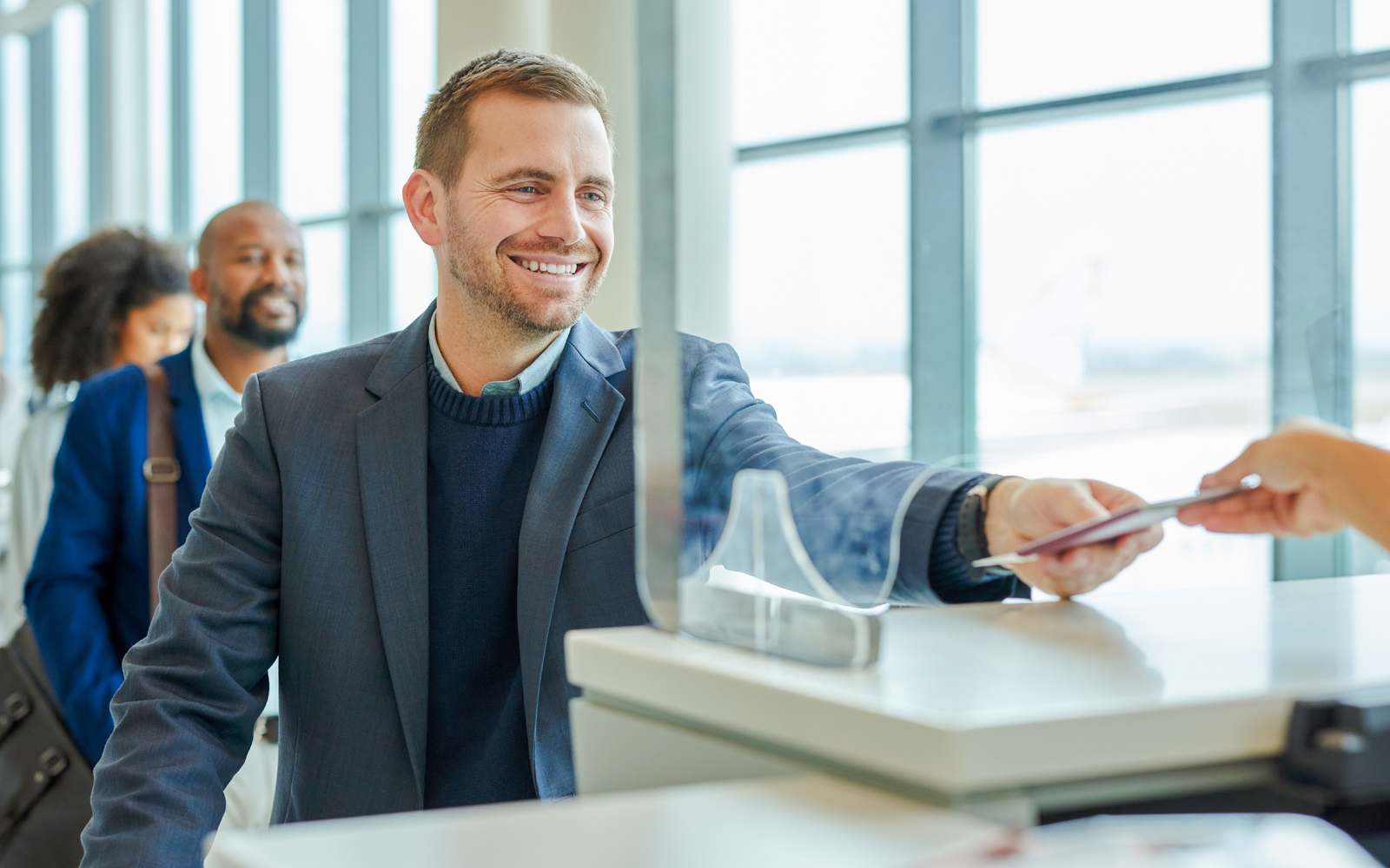 Person receiving tickets at a counter in a busy tourist attraction.