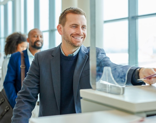 Person receiving tickets at a counter in a busy tourist attraction.