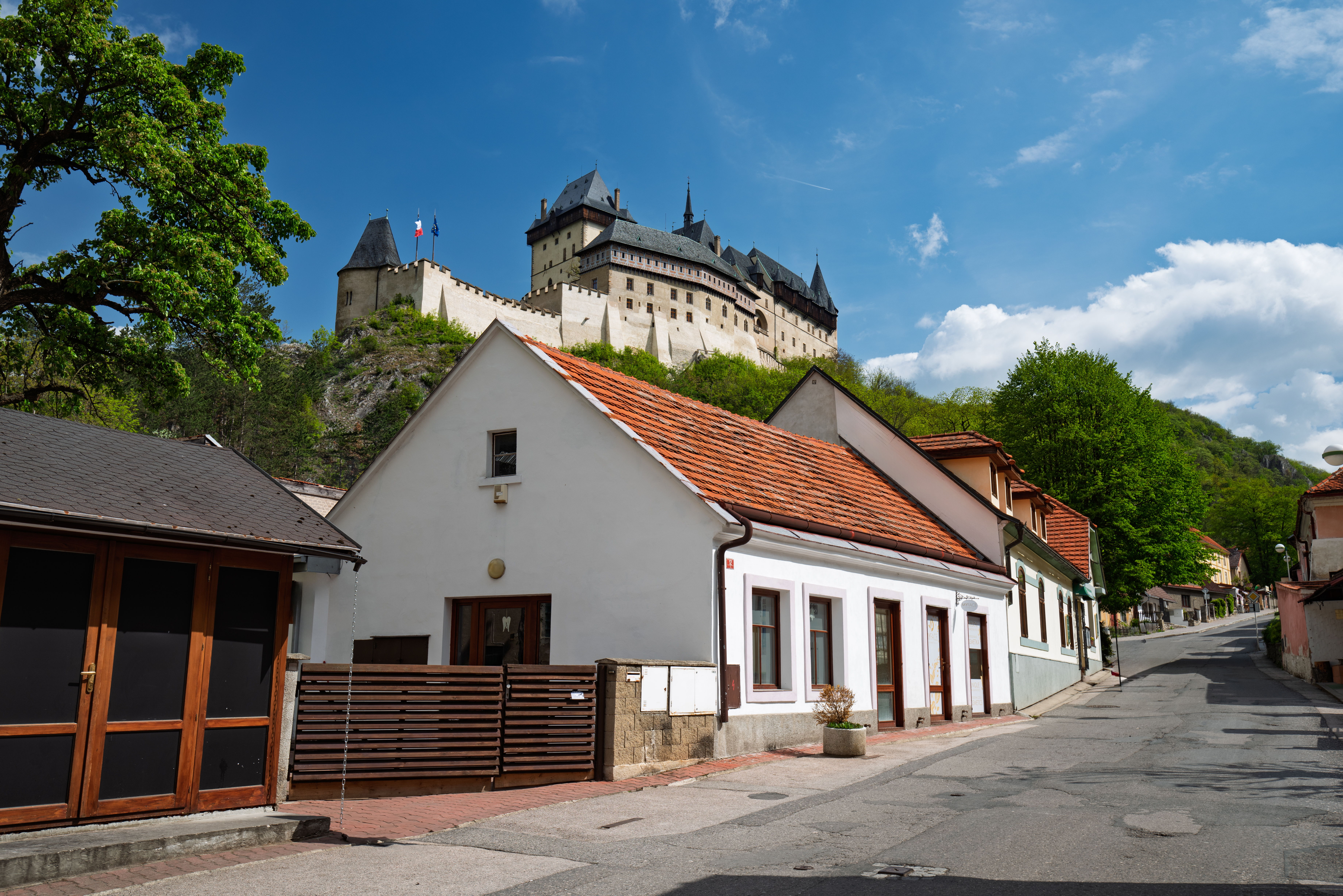 Czech houses with red tiled roofs below Karlstejn Castle.