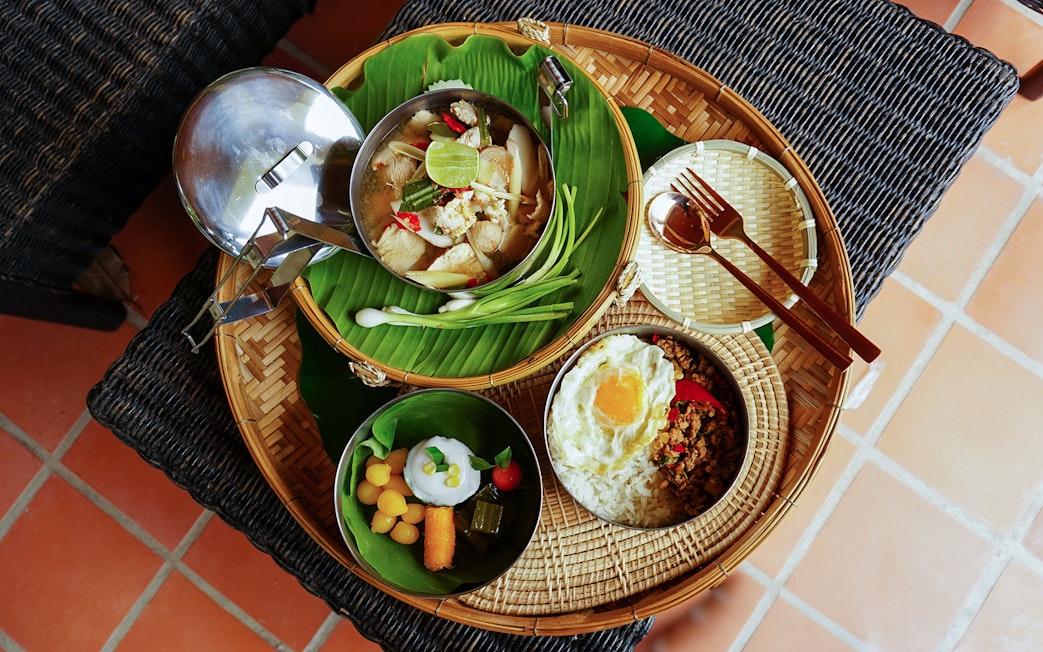 Traditional Thai lunch with rice, fried egg, soup, and desserts at Bangkok Elephant Park.