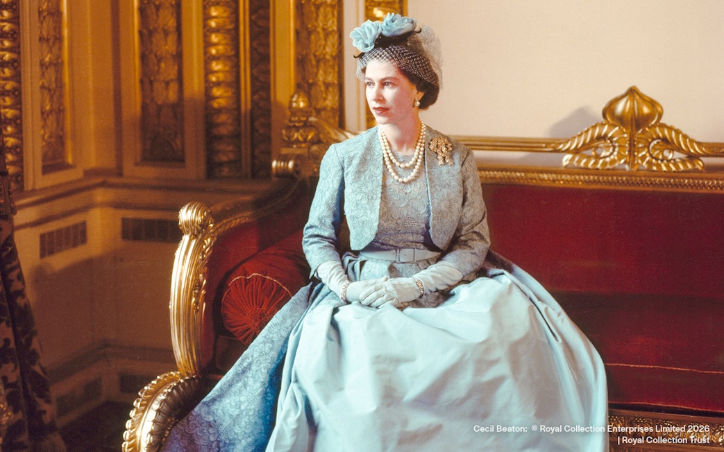 Royal figure in formal attire seated on ornate red sofa, Cecil Beaton, 1960.
