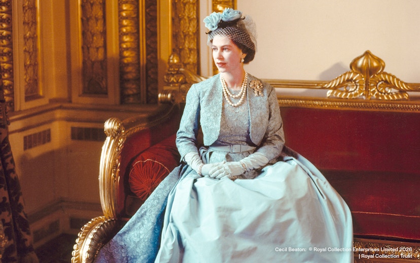 Royal figure in formal attire seated on ornate red sofa, Cecil Beaton, 1960.