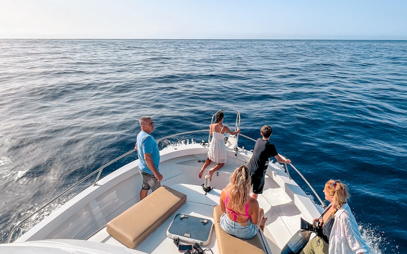 Tourists on a boat enjoying the ocean view during a dolphin and whale watching cruise in Gran Canaria.