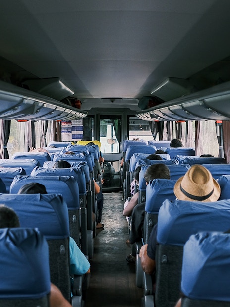 Passengers seated inside a tour bus traveling from Paris to Mont St. Michel's Abbey.