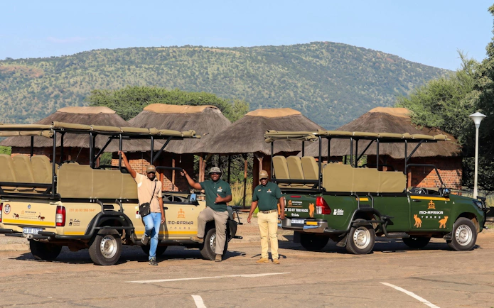 Guides with safari vehicles at Pilanesberg National Park.