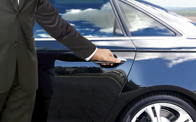 Private car door being opened for Tokyo airport transfer.