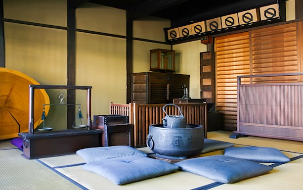 Traditional Japanese tea room setup with tatami mats and sake brewing tools.
