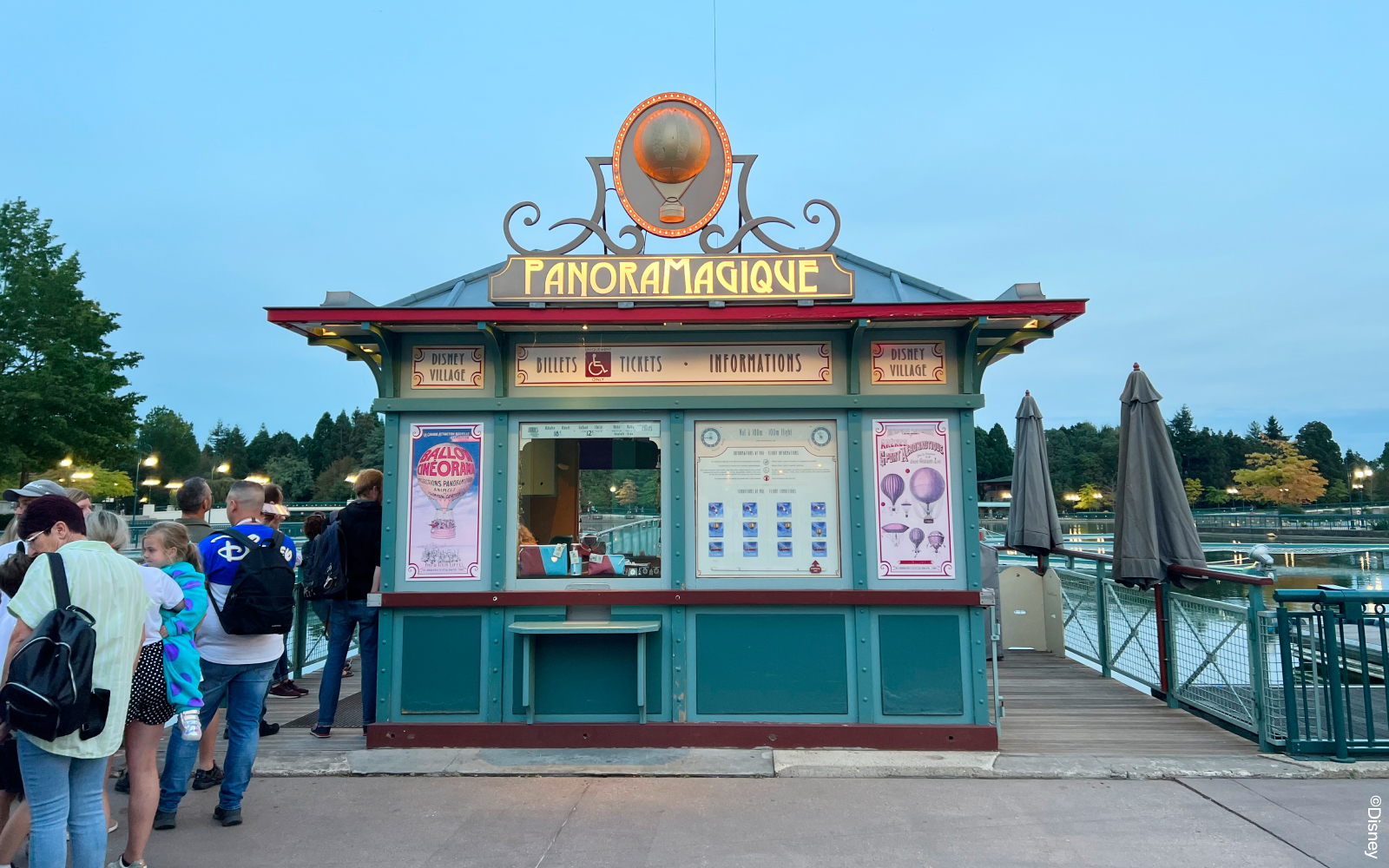 Disney Village entrance at Disneyland Paris with colorful shops and lively atmosphere.